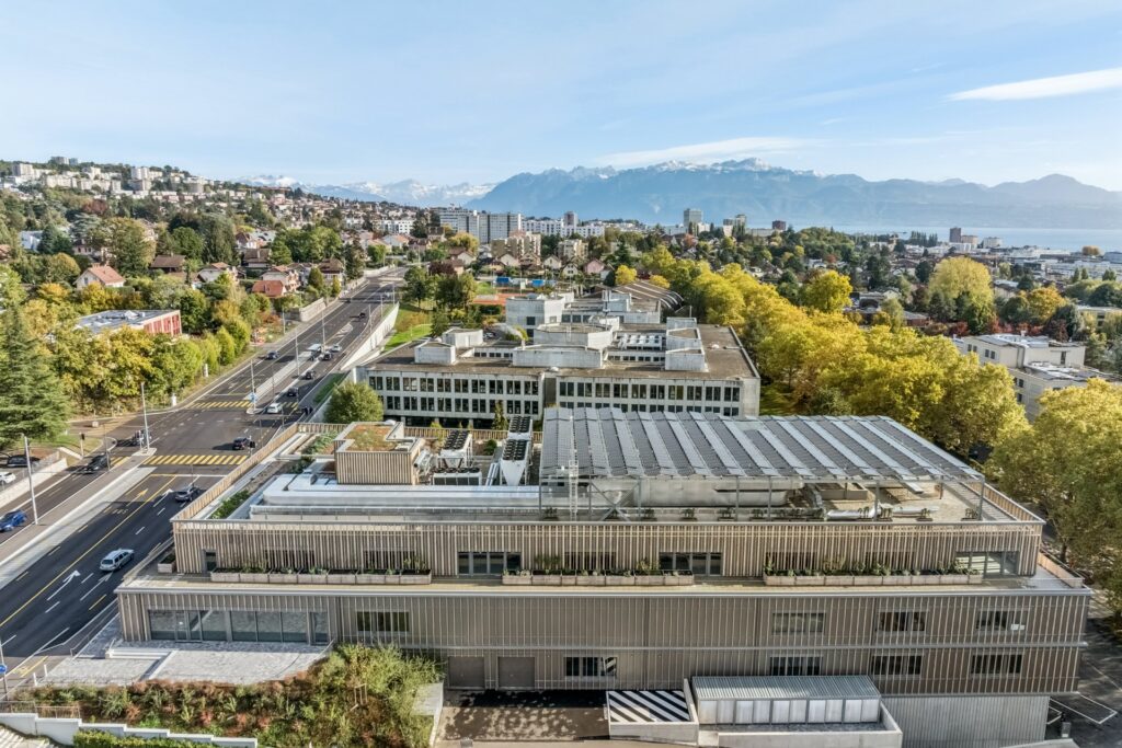 Vue aérienne de MixCity à Renens avec le lac Léman et les Alpes